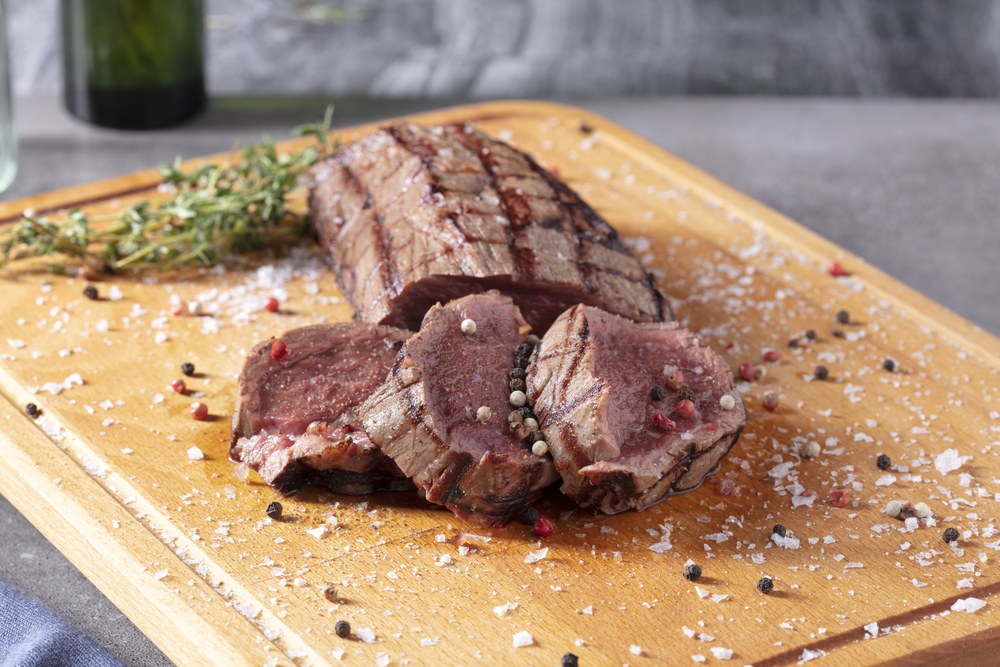 Deraliye Terrace - sliced tenderized beef tenderloin resting on a wooden board